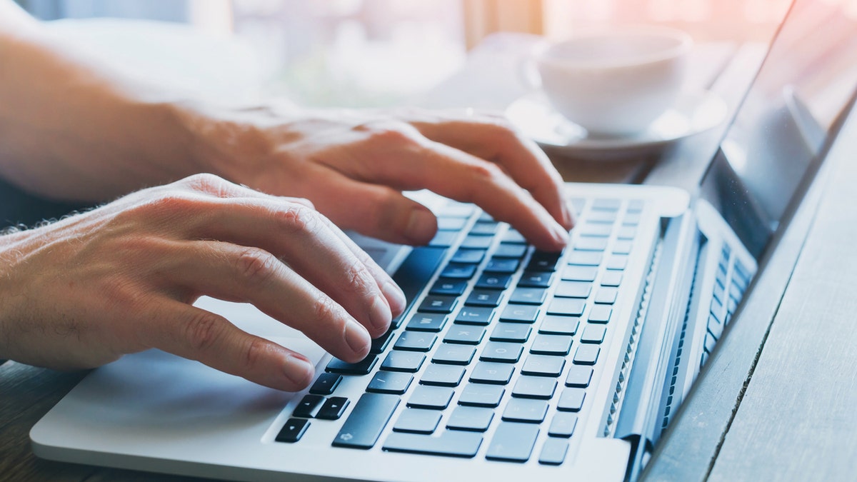 close up of hands of a person working on computer