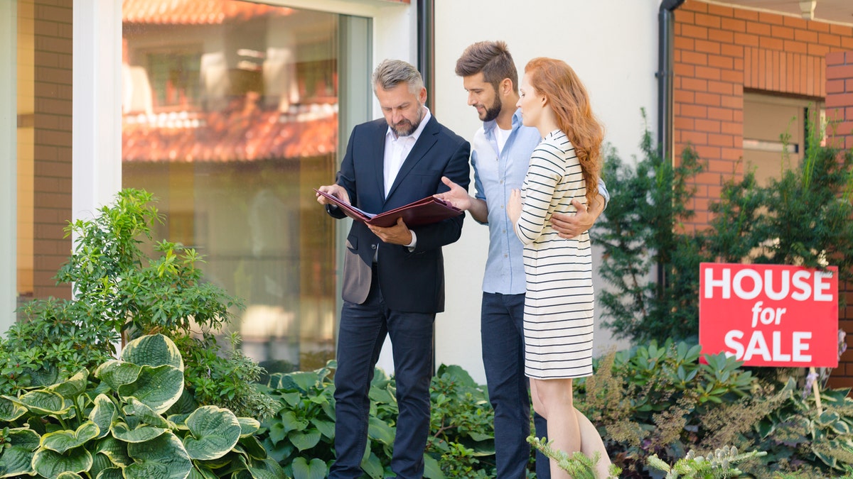 Young couple looking for apartment showing agent which property they want to buy