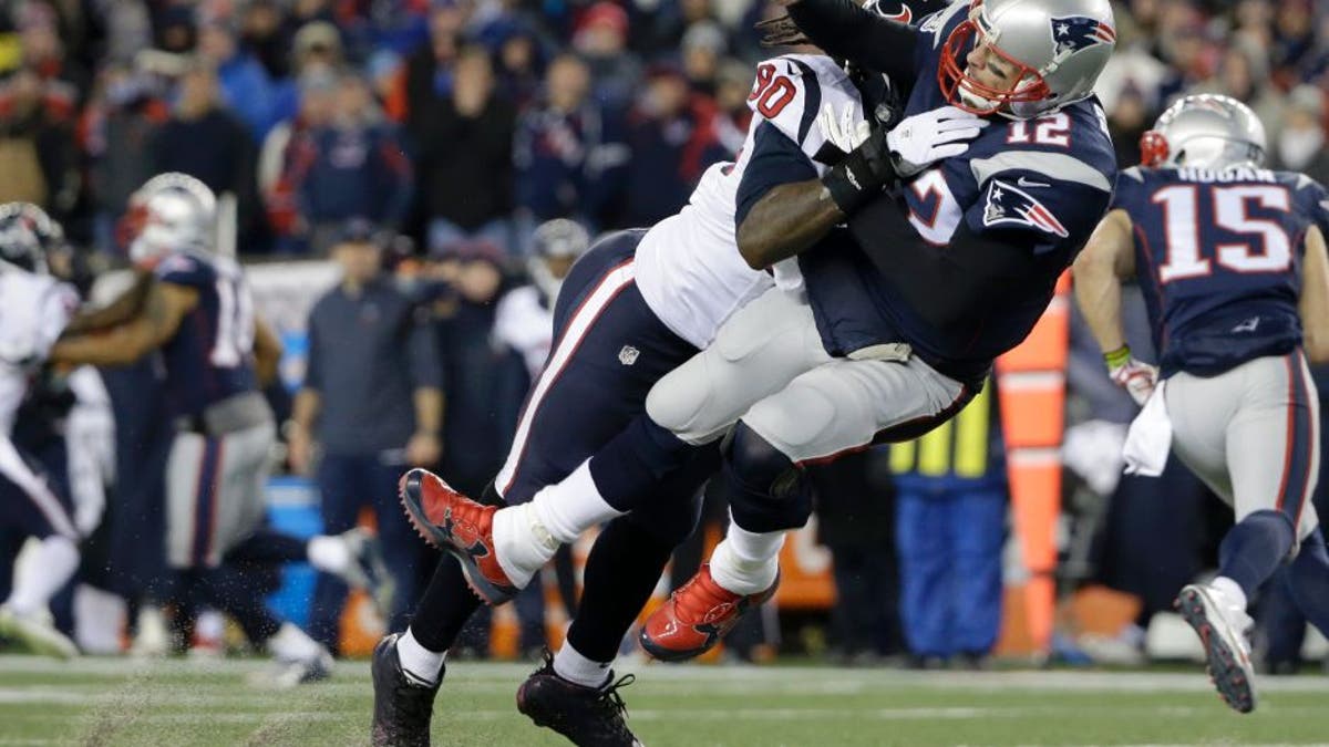 Houston Texans defensive end Jadeveon Clowney (90) levels New England Patriots quarterback Tom Brady (12) after Brady released a pass during the first half of an NFL divisional playoff football game, Saturday, Jan. 14, 2017, in Foxborough, Mass. (AP Photo/Elise Amendola)