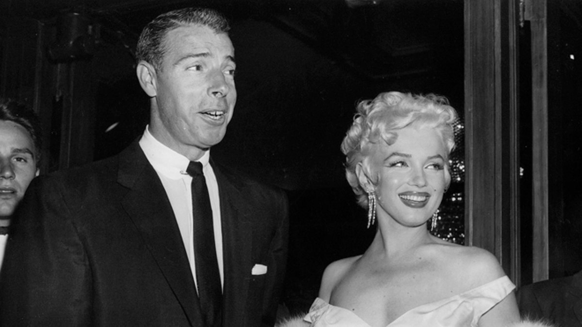 FILE - In this June 2, 1955 file photo, actress Marilyn Monroe, right, dressed in a glamorous evening gown, arrives with Joe DiMaggio at the theater. DiMaggio's love letter to Marilyn Monroe has sold for $78,125 at a Beverly Hills auction. Julien's Auctions in Beverly Hills says the letter, written by the baseball great after Monroe announced she was divorcing him, was sold Saturday, Dec. 6, 2014, to an undisclosed buyer.(AP Photo, File)