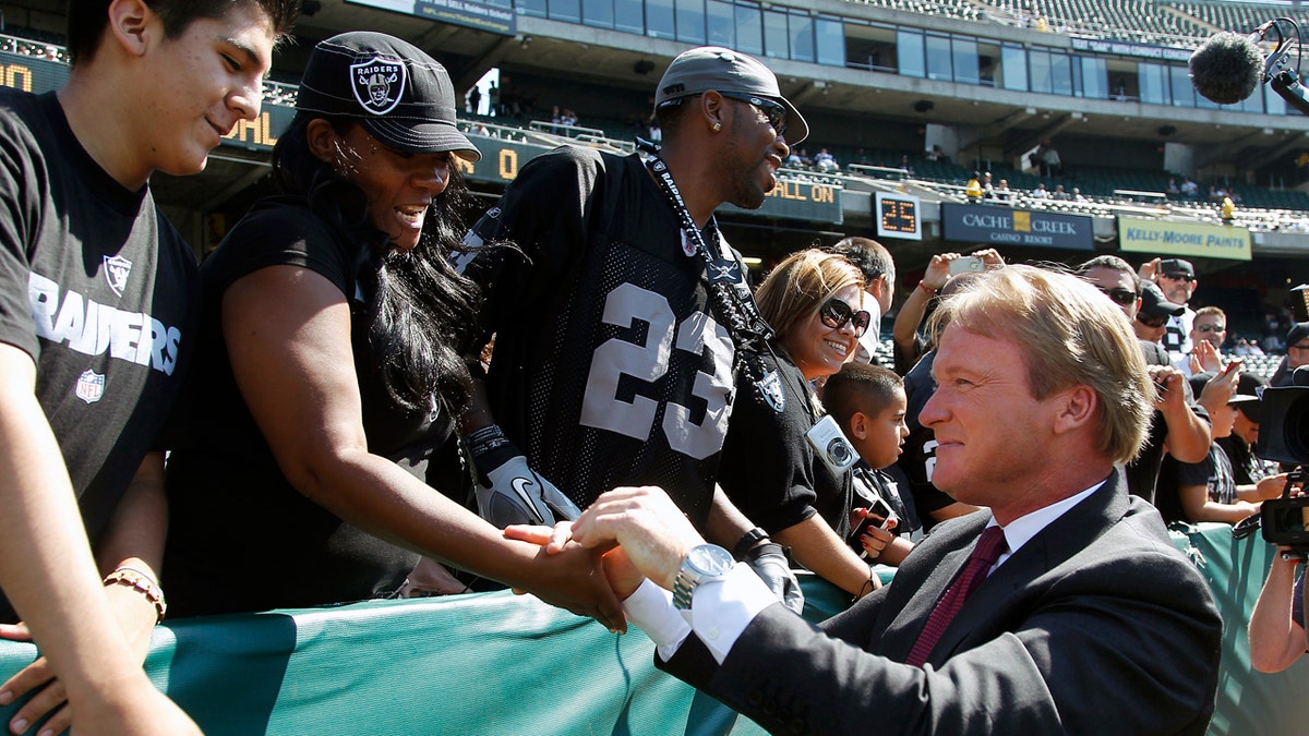 FILE - In this Aug. 13, 2012, file photo, NFL broadcaster and former Oakland Raiders head coach Jon Gruden greets fans before an NFL preseason football game between the Raiders and the Dallas Cowboys in Oakland, Calif. The Oakland Raiders are set to bring Jon Gruden back for a second stint as coach. A person with knowledge of the team's plans said the Raiders are planning a news conference Tuesday to announce that Gruden is leaving the broadcast booth to come back to coaching. The person spoke on condition of anonymity because the team has made no formal announcement. (AP Photo/Tony Avelar, File)