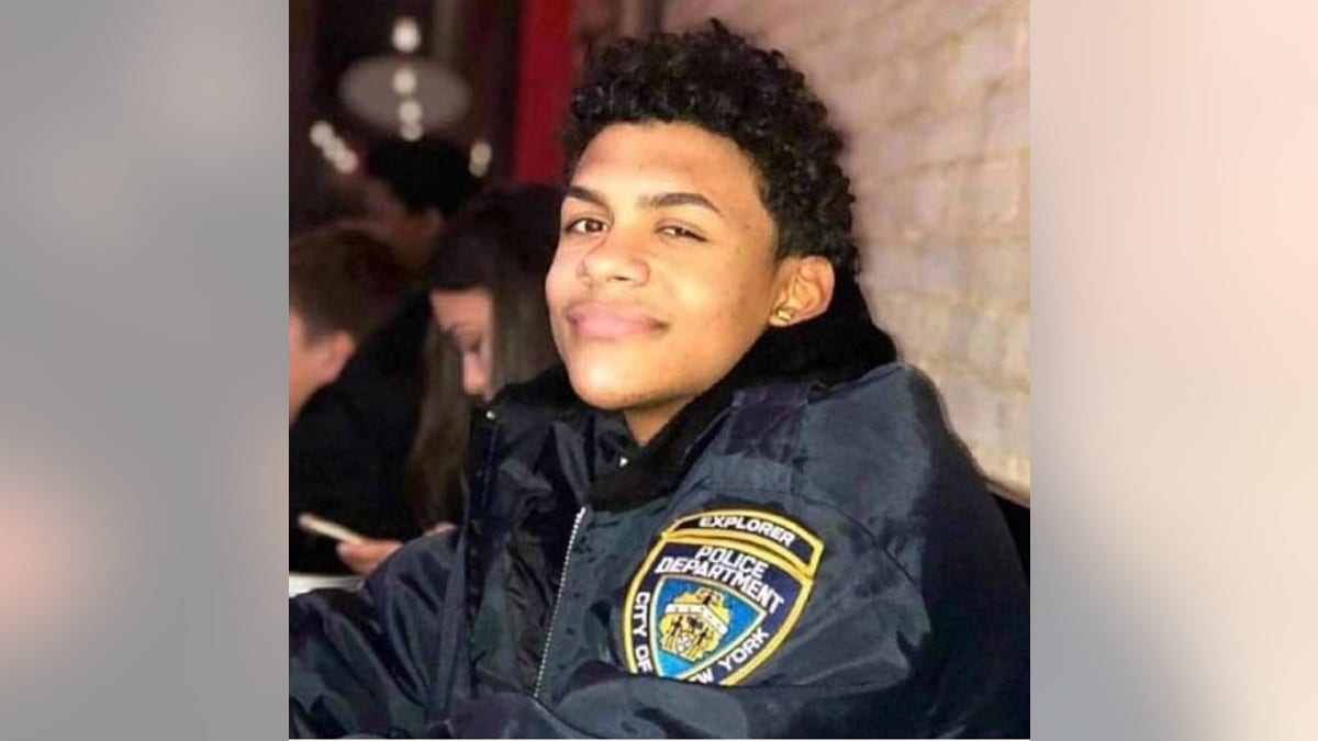 Lesandro "Junior" Guzman-Feliz smiles in a black police jacket