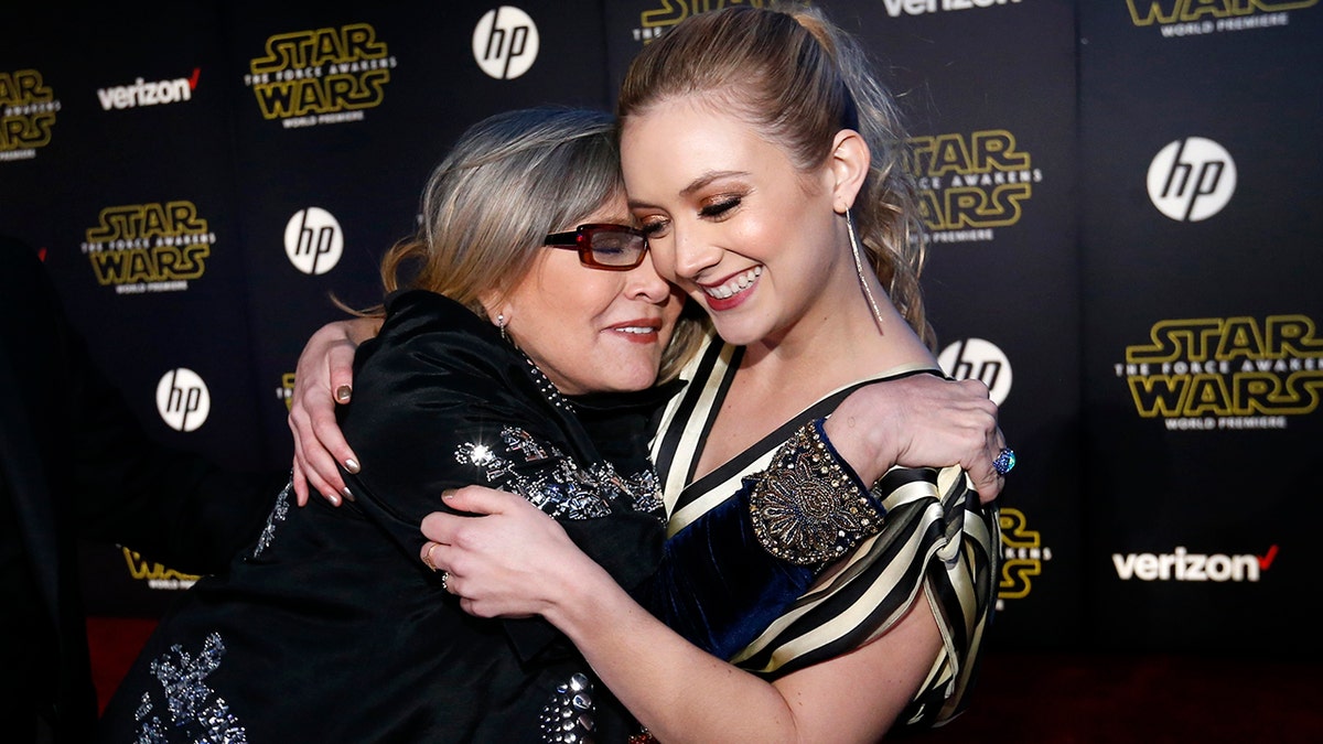 Actresses Carrie Fisher (L) and Billie Lourd embrace as they arrive at the premiere of 