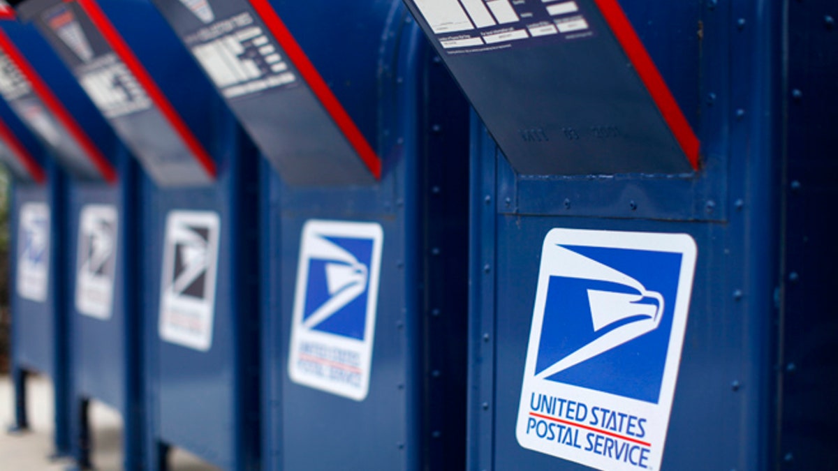 A view shows U.S. postal service mail boxes at a post office in Encinitas, California February 6, 2013. The Postal Service plans to drop Saturday delivery of first-class mail by August in its latest effort to cut costs after losing nearly $16 billion last fiscal year, the cash-strapped mail agency said on Wednesday. REUTERS/Mike Blake (UNITED STATES - Tags: BUSINESS EMPLOYMENT POLITICS) - RTR3DF9F