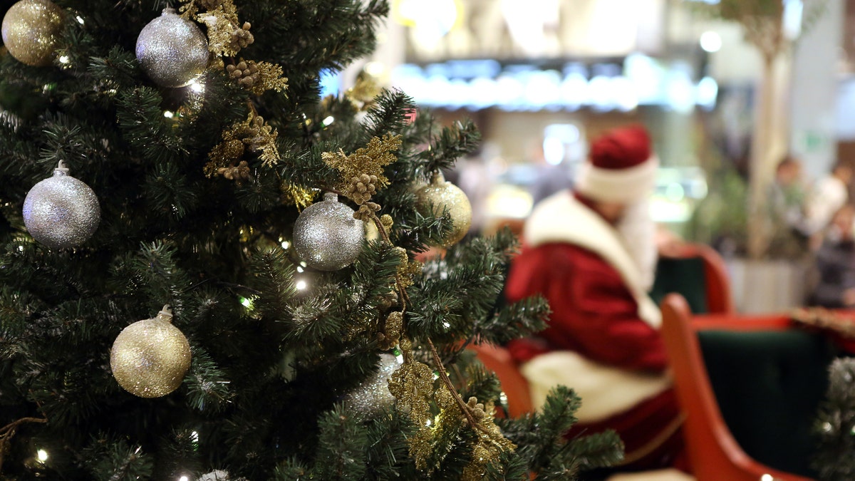 Santa Claus in Shopping Center on defocused lights background