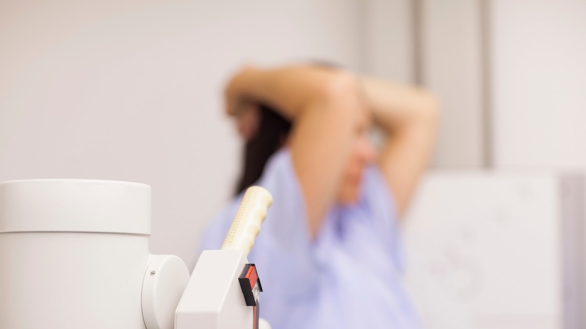 Medical machine next to a patient in an examination room during a breast cancer screening