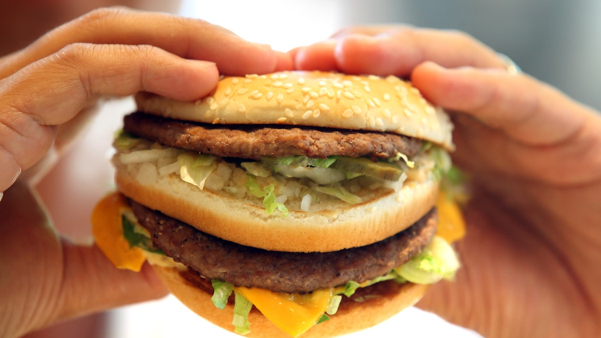 man's hands, holding onto a burger