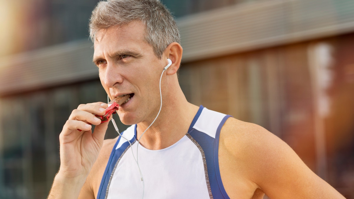 man eating energy bar power bar fitness istock large