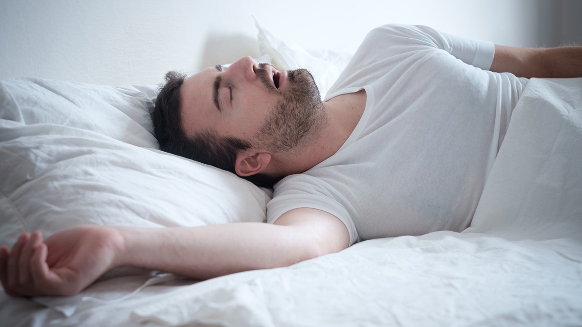 Man sleeping in his bed and snoring loudly