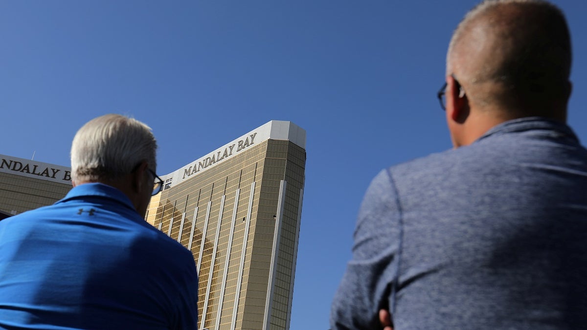 Tourists look up at the broken windows on the Mandalay Bay hotel from where shooter Stephen Paddock carried out his crime along the Las Vegas Strip in Las Vegas, Nevada, U.S., October 4, 2017.  REUTERS/Mike Blake - RC1995388F00