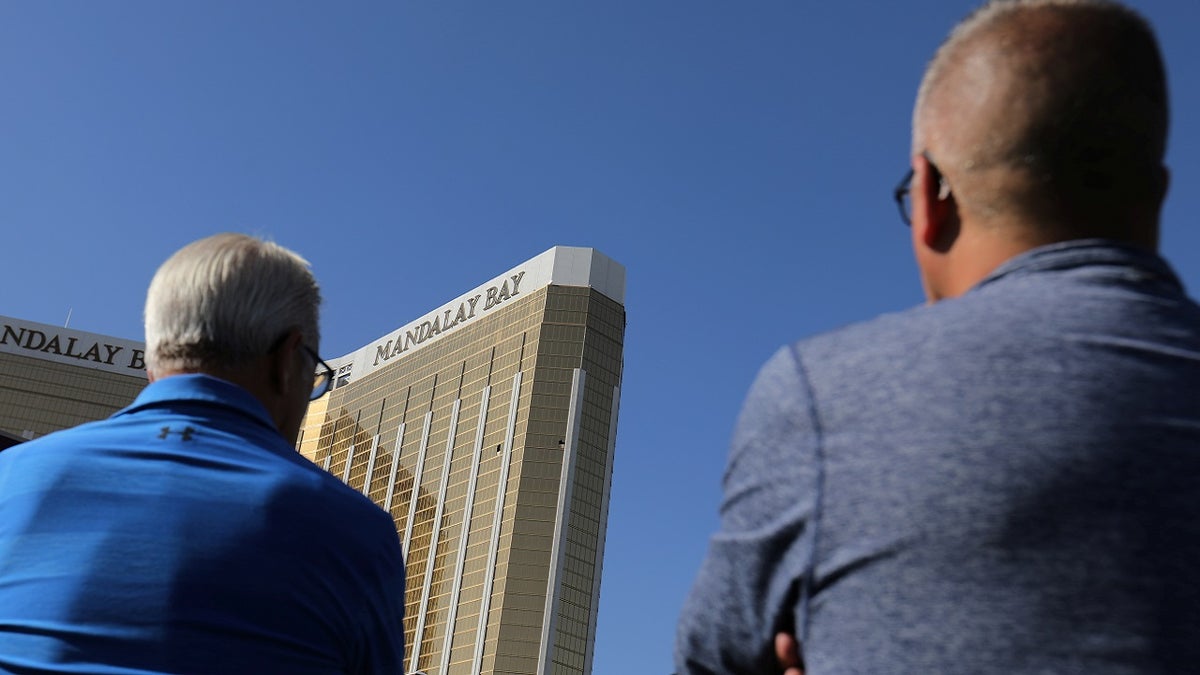 Tourists look up at the broken windows on the Mandalay Bay hotel from where shooter Stephen Paddock carried out his crime along the Las Vegas Strip in Las Vegas, Nevada, U.S., October 4, 2017. REUTERS/Mike Blake - RC1995388F00