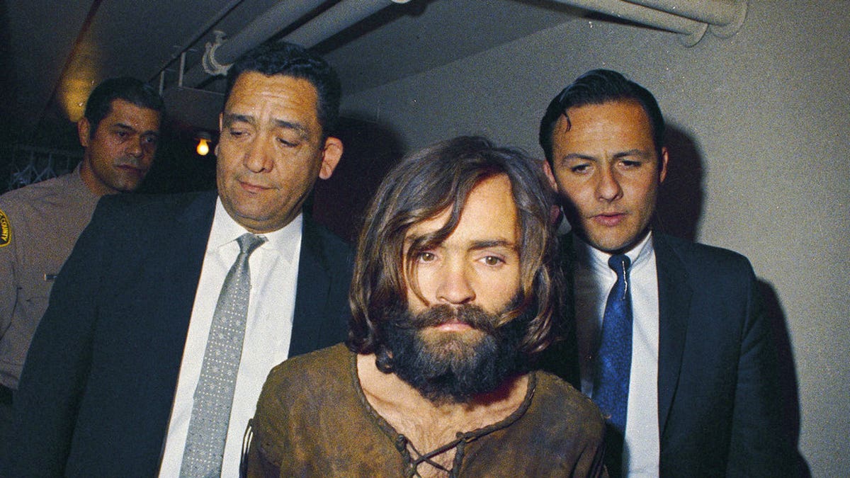 FILE - In this 1969 file photo, Charles Manson is escorted to his arraignment on conspiracy-murder charges in connection with the Sharon Tate murder case. Authorities say Manson, cult leader and mastermind behind 1969 deaths of actress Sharon Tate and several others, died on Sunday, Nov. 19, 2017. He was 83. (AP Photo, File)