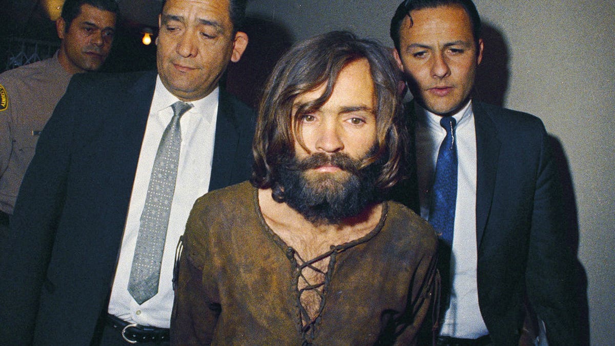 FILE - In this 1969 file photo, Charles Manson is escorted to his arraignment on conspiracy-murder charges in connection with the Sharon Tate murder case. Authorities say Manson, cult leader and mastermind behind 1969 deaths of actress Sharon Tate and several others, died on Sunday, Nov. 19, 2017. He was 83. (AP Photo, File)