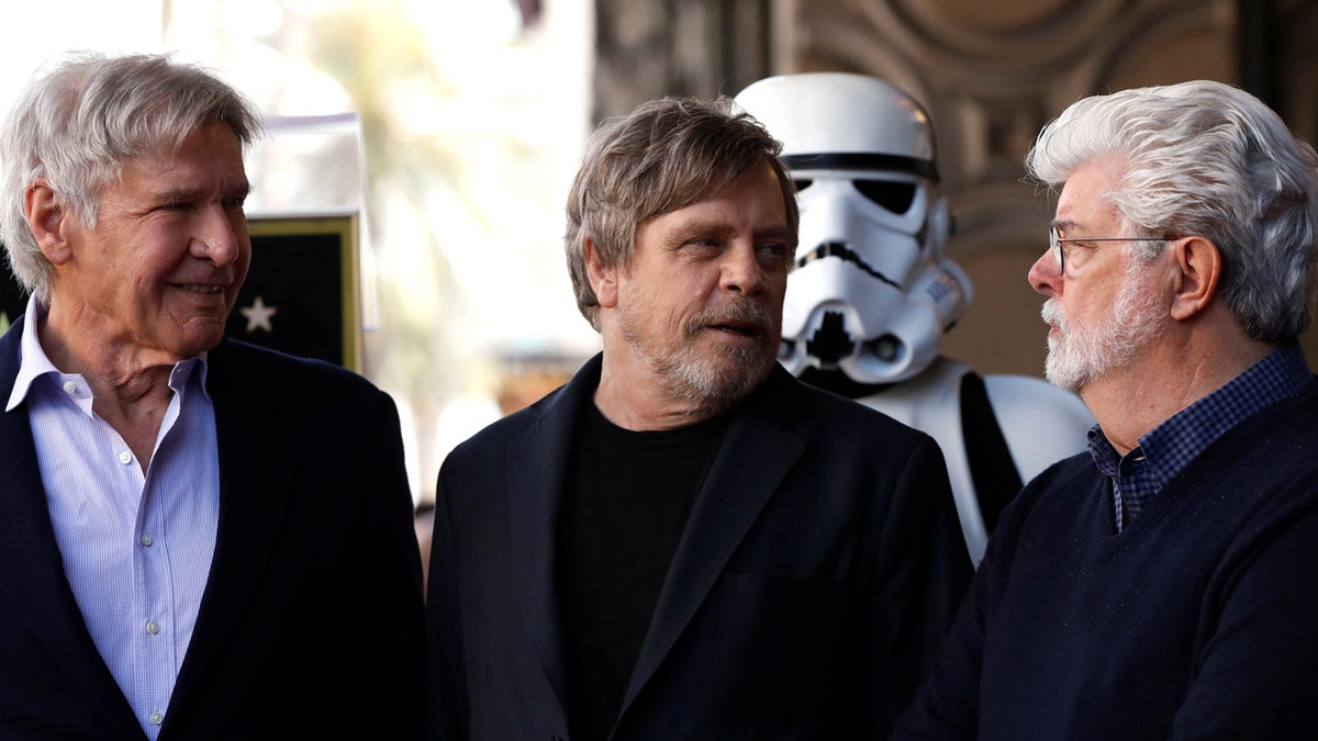 Actor Mark Hamill (C) talks with actor Harrison Ford (L) and filmmaker George Lucas after unveiling his star on the Hollywood Walk of Fame in Los Angeles, California, U.S., March 8, 2018. REUTERS/Mario Anzuoni - RC11CFEE6240