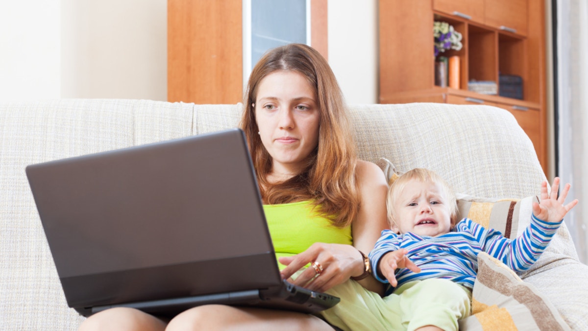 sorehead mother with crying toddler working online