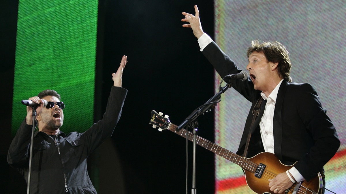 George Michael, left, and Paul McCartney, right, perform during the Live 8 concert in Hyde Park, London. The concert is part of a series of free concerts being held around the world designed to press leaders of the rich G8 countries to help impoverished African nations. Michael, who rocketed to stardom with WHAM! and went on to enjoy a long and celebrated solo career lined with controversies, has died, his publicist said Sunday, Dec. 25, 2016. He was 53. (AP Photo/Lefteris Pitarakis, File)