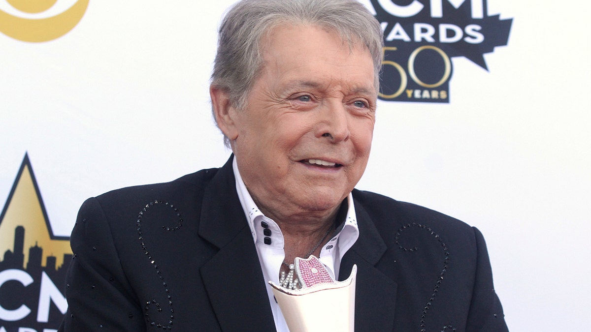 In this April 19, 2015 file photo, Mickey Gilley poses with the triple crown award on the red carpet at the 50th annual Academy of Country Music Awards at AT&T Stadium in Arlington, Texas. Country music artist Gilley and his son were injured in a car accident in Texas, but both are recovering after minor injuries. A statement from Gilley's publicist on Thursday, Jan. 4, 2018, said the two were injured Wednesday when their car rolled over.