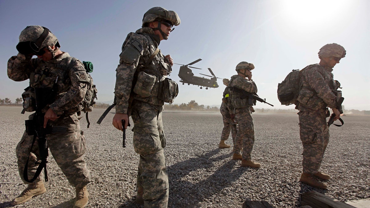 U.S soldiers from Task Force TF Yukon stand as a Chinook CH-47F transport helicopter prepares to land at FOB Salerno, Afghanistan, December 2, 2009. The top U.S. battlefield commander said on Wednesday that President Barack Obama's 30,000-strong troop increase for the Afghan war would make a huge difference, as the White House prepared to sell the new strategy to Congress. REUTERS/Zohra Bensemra (AFGHANISTAN MILITARY POLITICS CONFLICT IMAGES OF THE DAY) - GM1E5C21MXW01