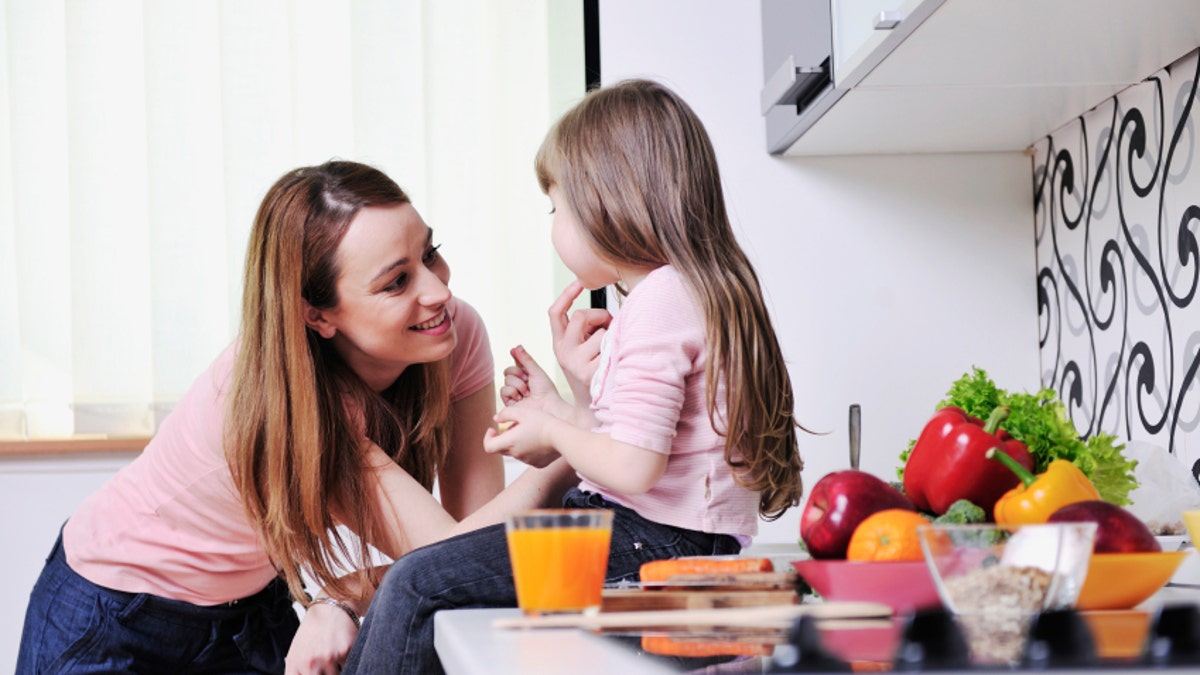 happy daughter and mom in kitchen