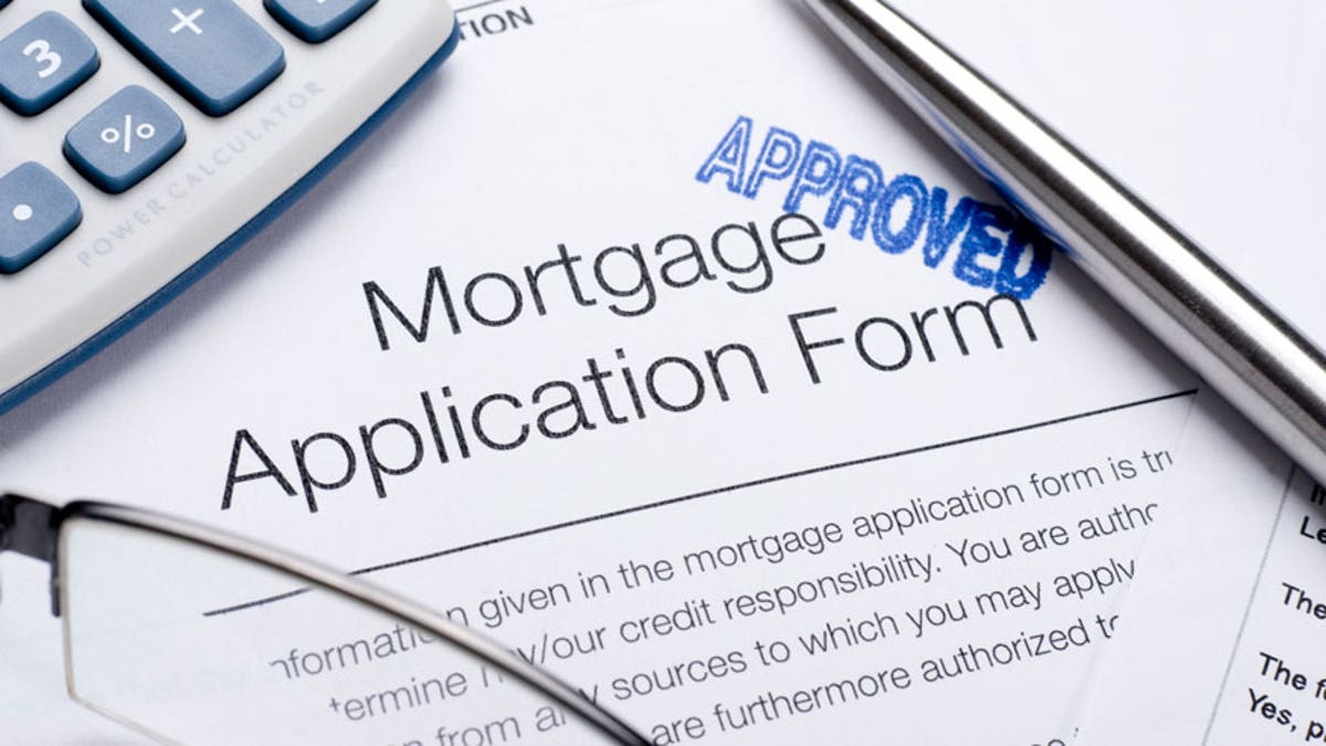 Approved Mortgage application form with a calculator and pen