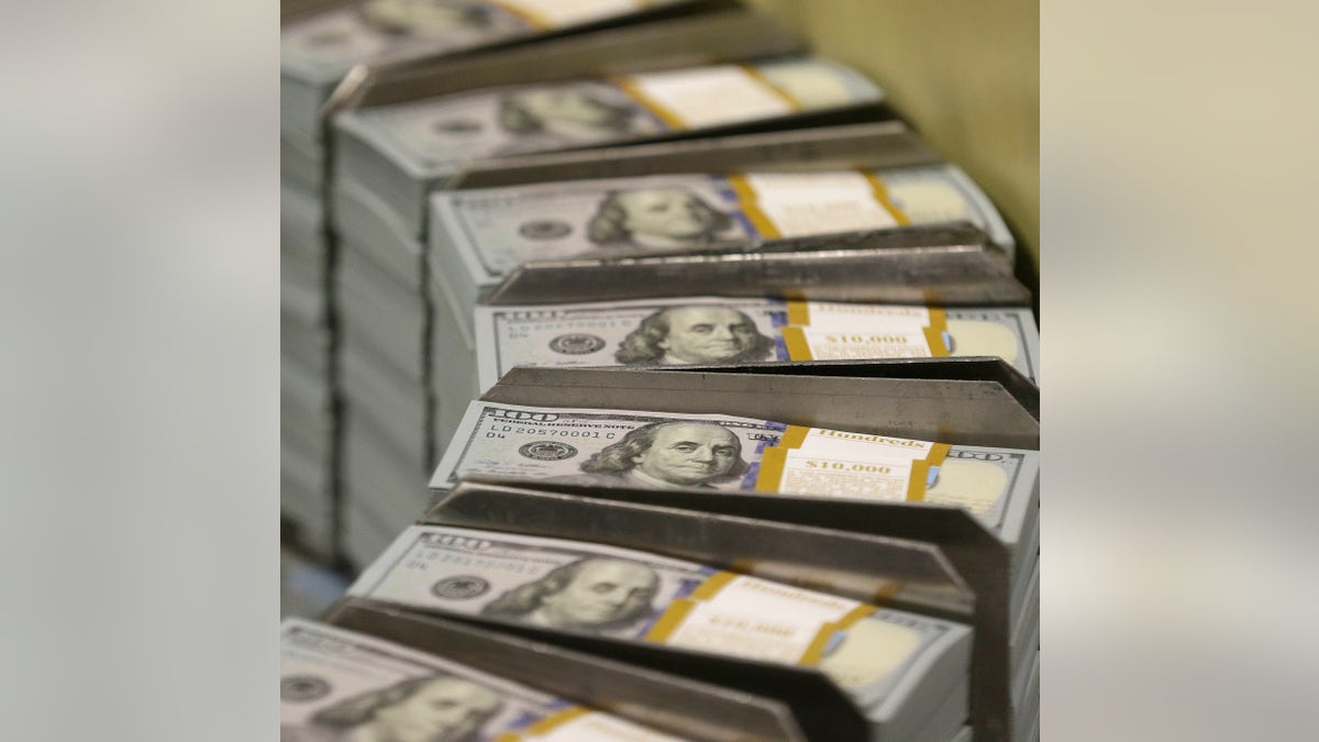 In this photo taken Sept. 24, 2013, just cut stacks of $100 bills make their way down the line at the Bureau of Engraving and Printing Western Currency Facility in Fort Worth, Texas. The nationâs health care tab is expected to surpass $10,000 per person for the first time this year, the government said Wednesday. The new peak suggests the Obama administration will pass the problem of high health care costs on to its successor. (AP Photo/LM Otero)