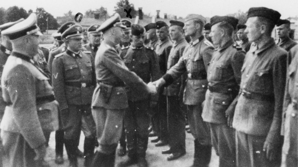 This 1942 photo provided by the the public prosecutor's office in Hamburg via the United States Holocaust Memorial Museum, shows Heinrich Himmler, center left, shaking hands with new guard recruits at the Trawniki concentration camp in Nazi occupied Poland. Trawniki is the same camp, where some time after this photo was made, Jakiw Palij trained and served as a guard. The White House says that Palij, a 95-year-old former Nazi concentration camp guard has been deported to Germany, 14 years after a judge ordered his expulsion. (public prosecutor's office in Hamburg via the United States Holocaust Memorial Museum via AP)