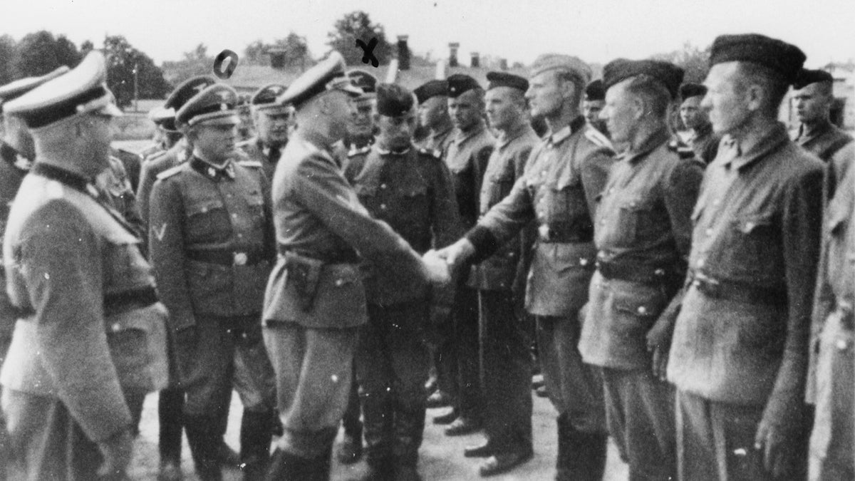 This 1942 photo provided by the the public prosecutor's office in Hamburg via the United States Holocaust Memorial Museum, shows Heinrich Himmler, center left, shaking hands with new guard recruits at the Trawniki concentration camp in Nazi occupied Poland. Trawniki is the same camp, where some time after this photo was made, Jakiw Palij trained and served as a guard. The White House says that Palij, a 95-year-old former Nazi concentration camp guard has been deported to Germany, 14 years after a judge ordered his expulsion. (public prosecutor's office in Hamburg via the United States Holocaust Memorial Museum via AP)