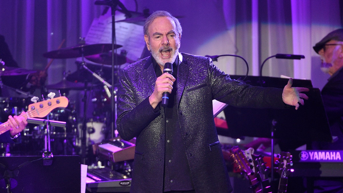 File- This Feb. 11, 2017, file photo shows Neil Diamond performing at the Clive Davis and The Recording Academy Pre-Grammy Gala at the Beverly Hilton Hotel in Beverly Hills, Calif.  Diamond is retiring from touring after he says he was diagnosed with Parkinsonâs disease. Days shy of his 77th birthday, the rock legend is canceling his tour dates in Australia and New Zealand for March. He was on his 50th anniversary tour. Diamond turns 77 on Wednesday and will get the lifetime achievement award at Sundayâs Grammy awards.  (Photo by Chris Pizzello/Invision/AP)