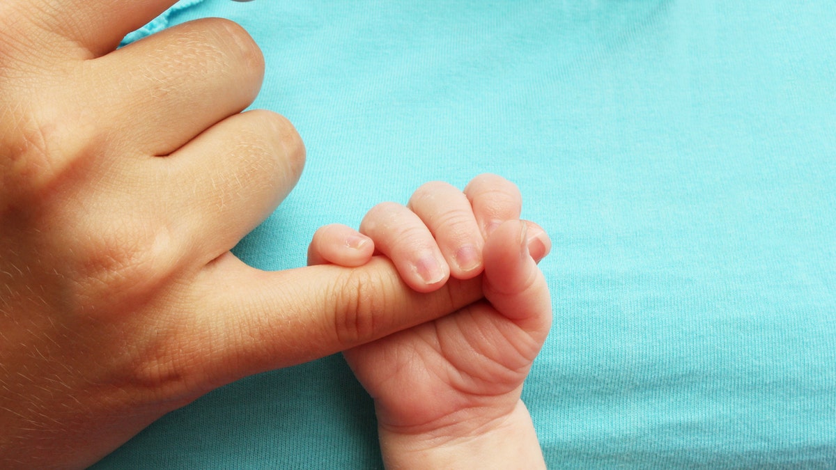 newborn baby with mom finger istock