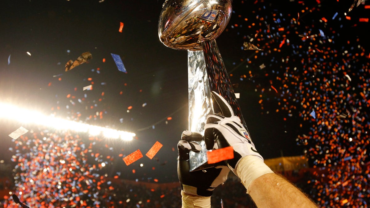 The Vince Lombardi Trophy is lifted into the air after the New Orleans Saints defeated the Indianapolis Colts in the NFL's Super Bowl XLIV football game in Miami, Florida, February 7, 2010.     REUTERS/Mike Segar (UNITED STATES) - RTR29YJ0