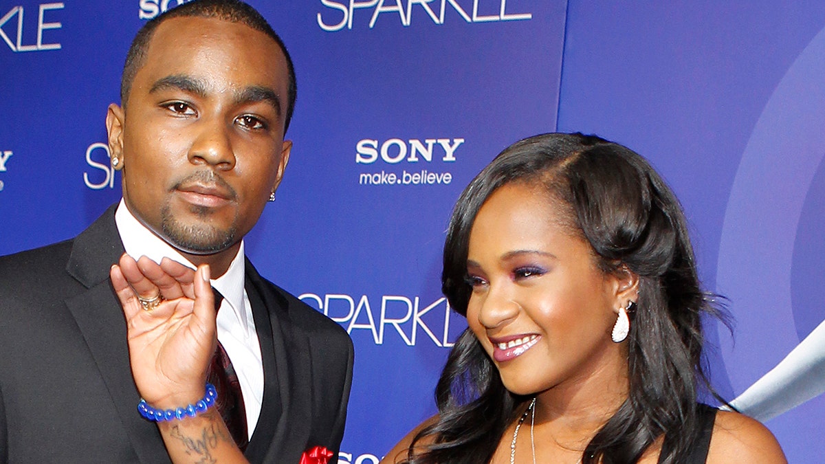 Bobbi Kristina Brown, daughter of the late singer Whitney Houston, waves while arriving with boyfriend Nick Gordon at the premiere of the new film