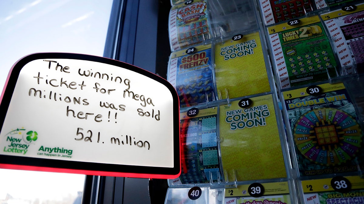 A sign is displayed near scratch-off tickets inside a Lukoil service station where the winning ticket for the Mega Millions lottery drawing was sold, Saturday, March 31, 2018, in Riverdale, N.J. (AP Photo/Julio Cortez)