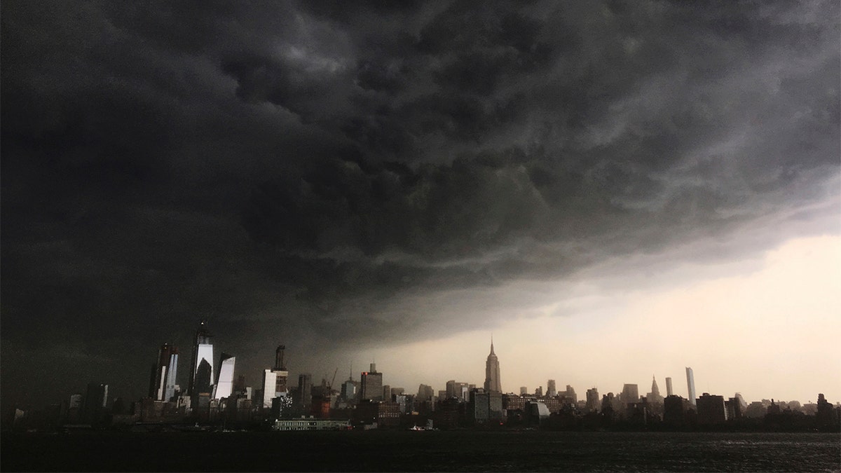 In this Tuesday, May 15, 2018 photo, storm clouds gather over New York city seen from the Hudson River. A line of strong storms pushed across New York City and badly disrupted the evening commute, stranding thousands of train riders. (AP Photo/Denis Paquin)