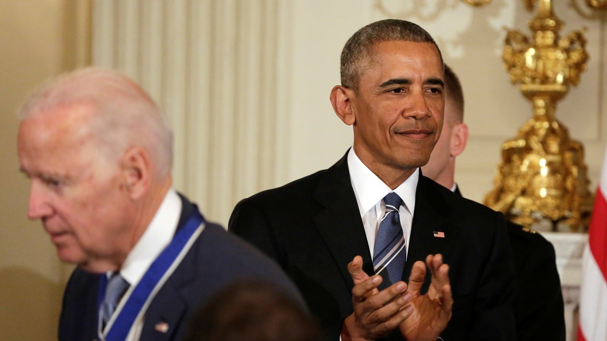 U.S. President Barack Obama (R) applauds after presenting the Presidential Medal of Freedom to Vice President Joe Biden in the State Dining Room of the White House in Washington, U.S., January 12, 2017. REUTERS/Yuri Gripas - RTX2YQ15