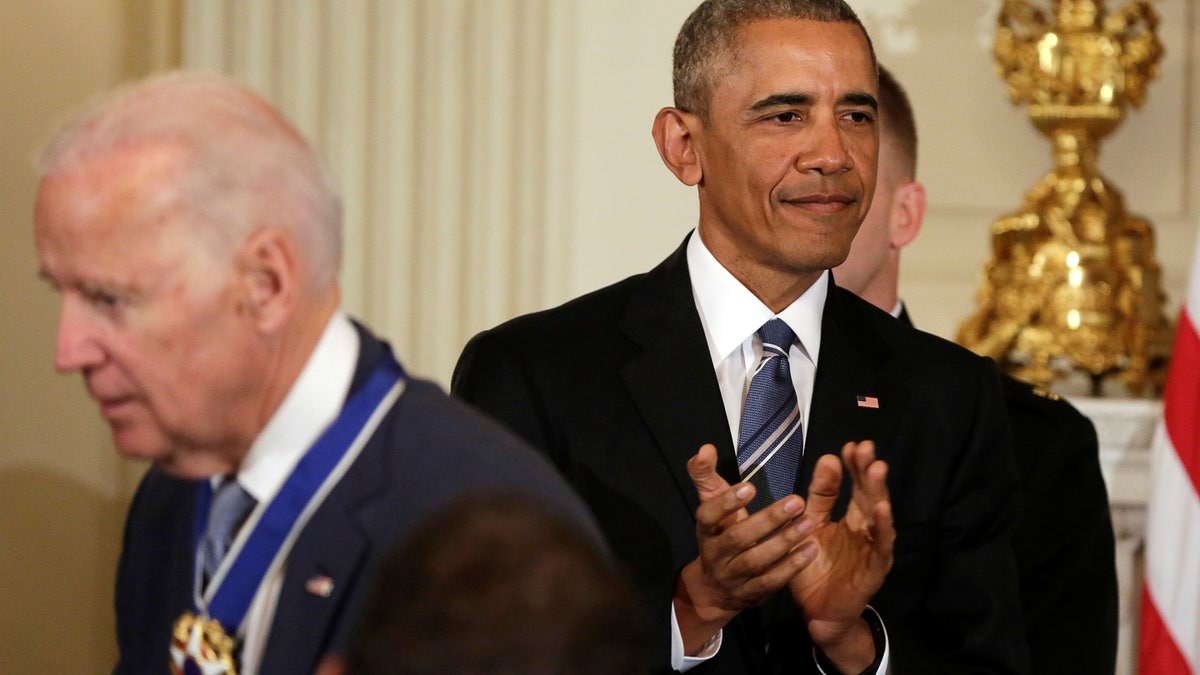 U.S. President Barack Obama (R) applauds after presenting the Presidential Medal of Freedom to Vice President Joe Biden in the State Dining Room of the White House in Washington, U.S., January 12, 2017. REUTERS/Yuri Gripas - RTX2YQ15