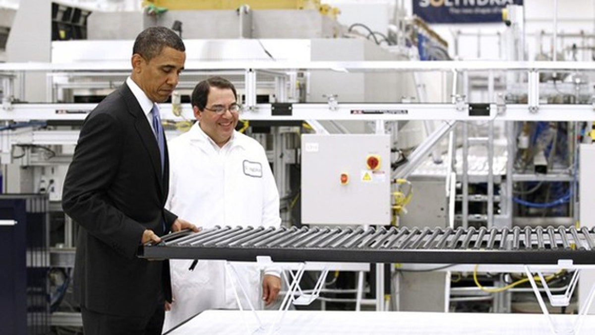 May 26, 2010: President Obama lifts a solar panel as he tours a Solyndra facility in Fremont, Calif.