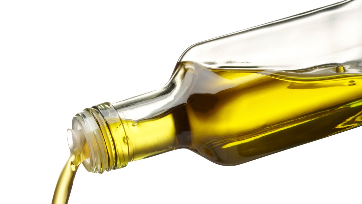olive oil being poured from glass bottle