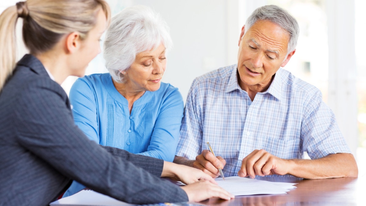 Financial Advisor Explaining Investment Plans To Senior Couple.