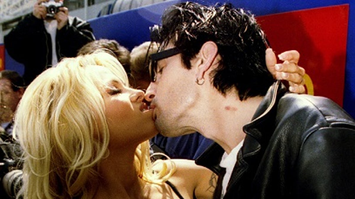 Baywatch star Pamela Anderson kisses her husband Tommy Lee at the launch of a new Virgin soft drink May 22. The drink called 'Virgin Energy' is claimed to have aphrodisiac properties - PBEAHUNBICW