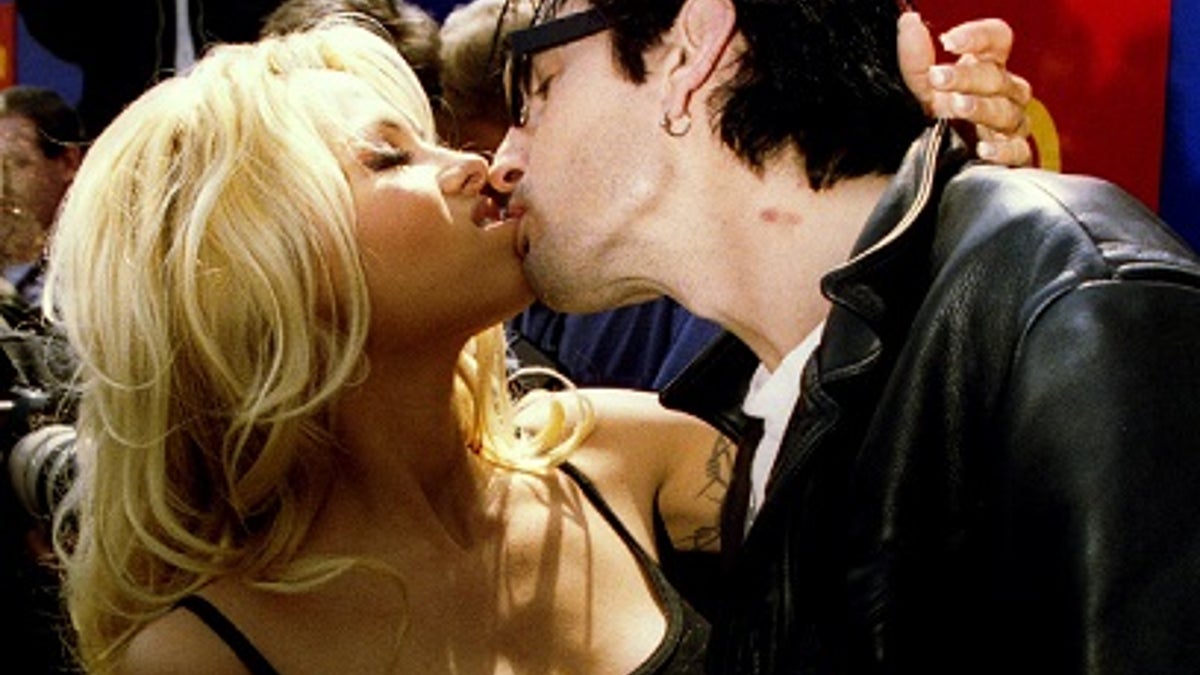 Baywatch star Pamela Anderson kisses her husband Tommy Lee at the launch of a new Virgin soft drink May 22. The drink called 'Virgin Energy' is claimed to have aphrodisiac properties - PBEAHUNBICW