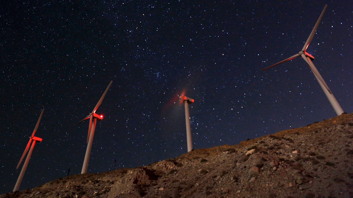 A meteor (top L) speeds past windmills at the San Gregornio Pass Wind Farm near Whitewater, California, August 13, 2015. The annual Perseid meteor shower is occurring during an upcoming new moon, making for stelar viewing conditions, according to NASA. REUTERS/Sam Mircovich - RTR4YZ6X