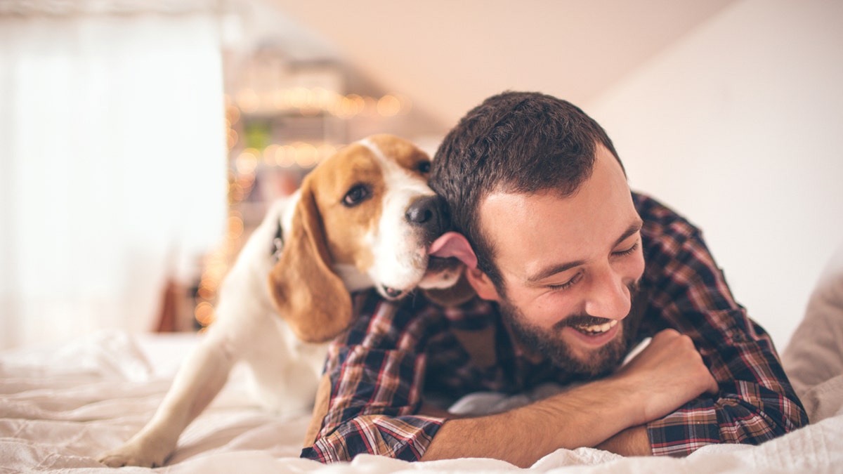 Young smiling man affectionate with his dog 