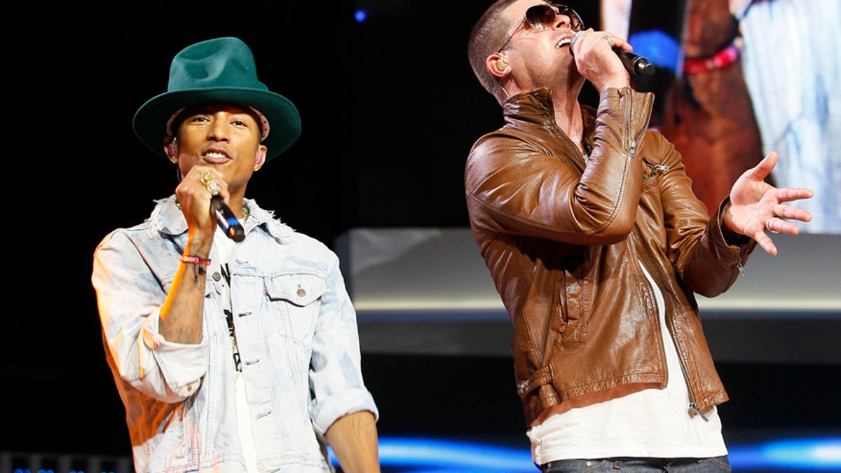 Singer Pharrell Williams (L) and singer Robin Thicke perform together at the Walmart annual shareholders meeting in Fayetteville, Arkansas June 6, 2014.