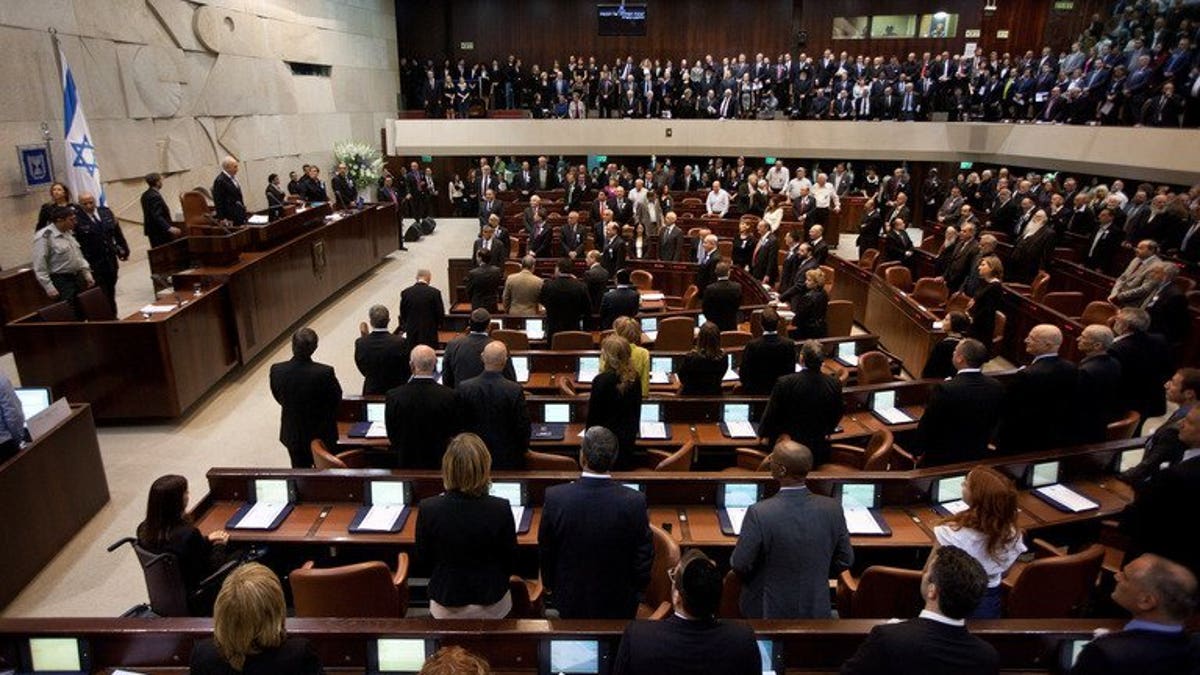 Israeli lawmakers stand during a swearing-in ceremony at the Knesset in Jerusalem, on February 5, 2013. Israel's parliament has taken the first tentative steps towards reining in the country's extreme form of proportional representation in a bid to make governments more stable.