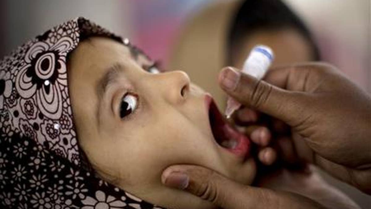 Feb. 16, 2015: In this photo, a Pakistani health worker gives polio vaccine to a child at a bus terminal in Rawalpindi, Pakistan.