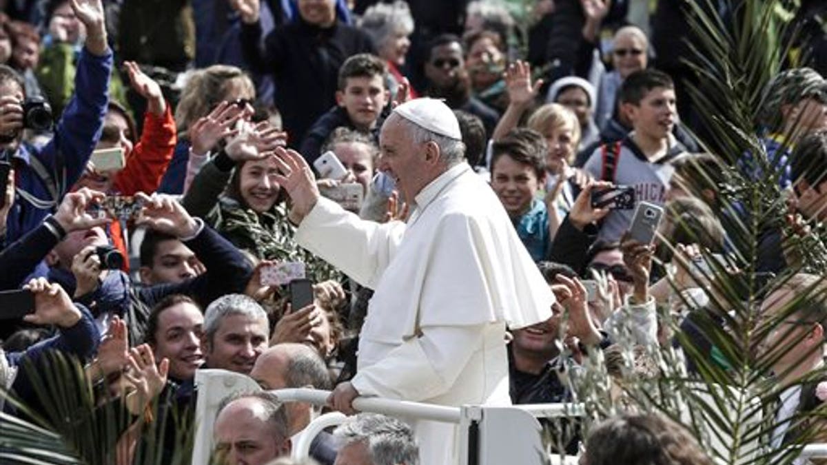 Pope Francis greets faithful after celebrating Palm Sunday Mass
