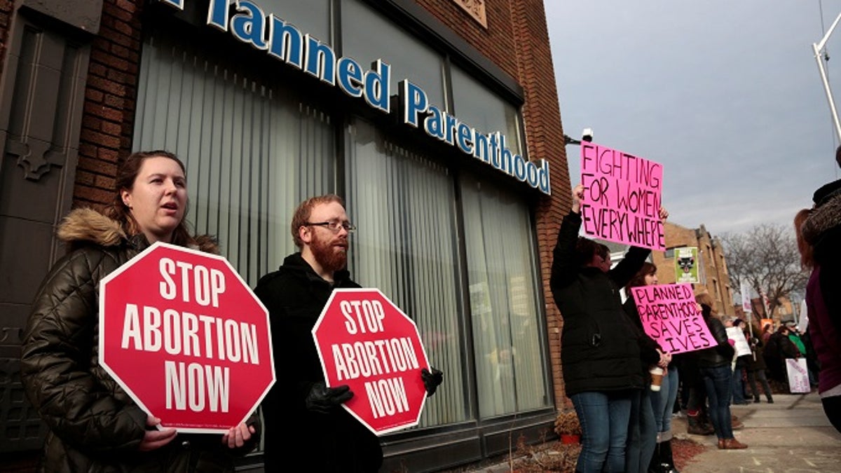 Anti-abortion activists (L) rally next to supporters of Planned Parenthood outside a Planned Parenthood clinic in Detroit, Michigan, U.S. February 11, 2017.  REUTERS/Rebecca Cook - RC162DF524F0