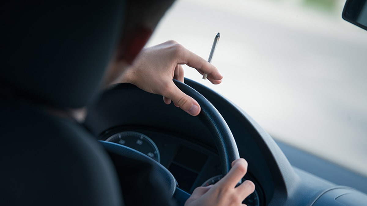 Man driving and smoking joint