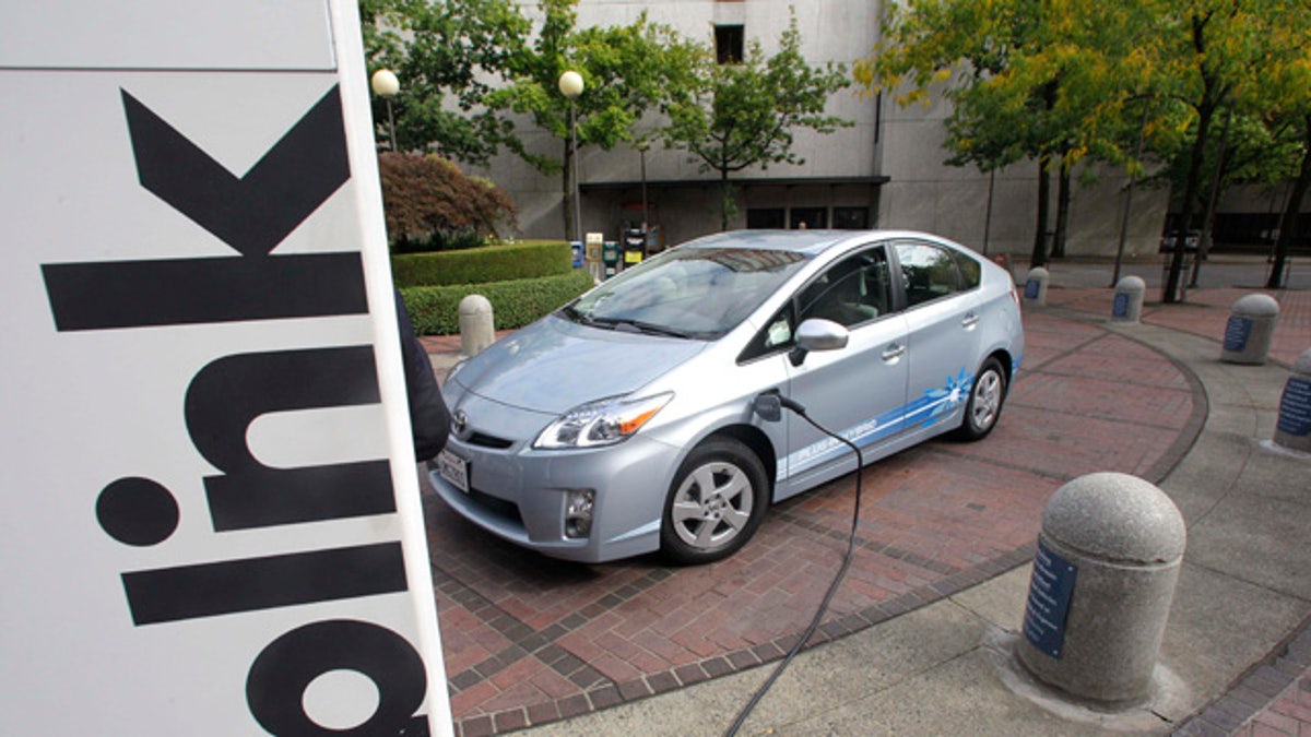 A Toyota Prius Hybrid charges during the unveiling of the Blink electric vehicle charging station that will charge up vehicles in Portland and other key metropolitan areas Wednesday, Sept. 22, 2010, in Portland, Ore. (AP Photo/Rick Bowmer)