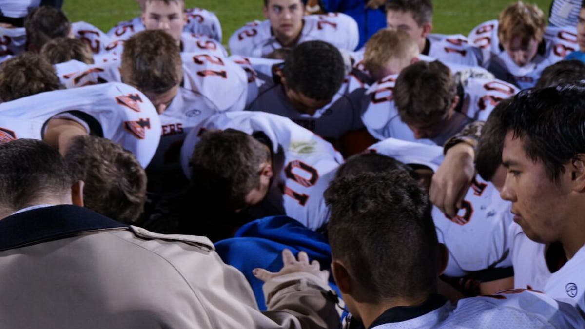 Kennedy praying on the field after the high school's homecoming game.
